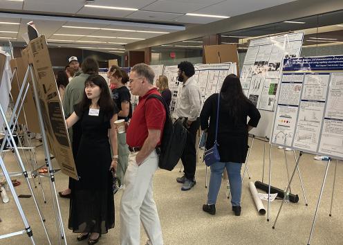 student presenting poster to faculty member